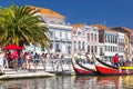 Aveiro, Portugal Ã¢â¬â May 3, 2019: Moliceiro traditional boats docked along the central canal with cozy houses in Aveiro.